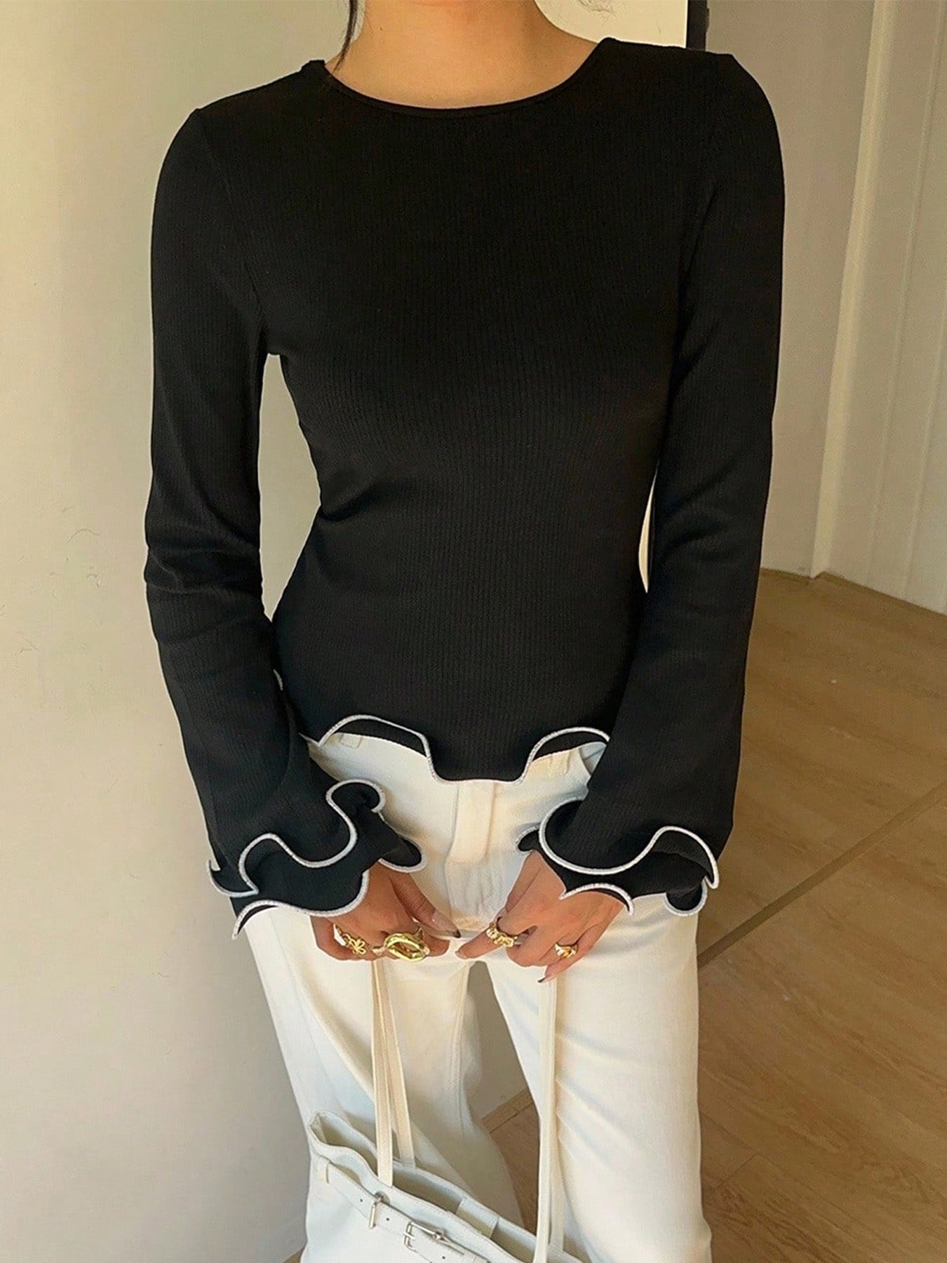 Black crew neck long sleeve t-shirt with ruffled cuffs and hem