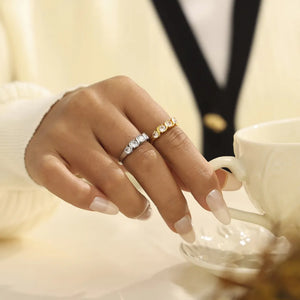 Gold and silver band rings with clear cubic zirconia stones, stacked on fingers.