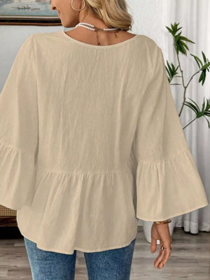 Apricot cotton V-neck blouse with bell sleeves and peplum hem.
