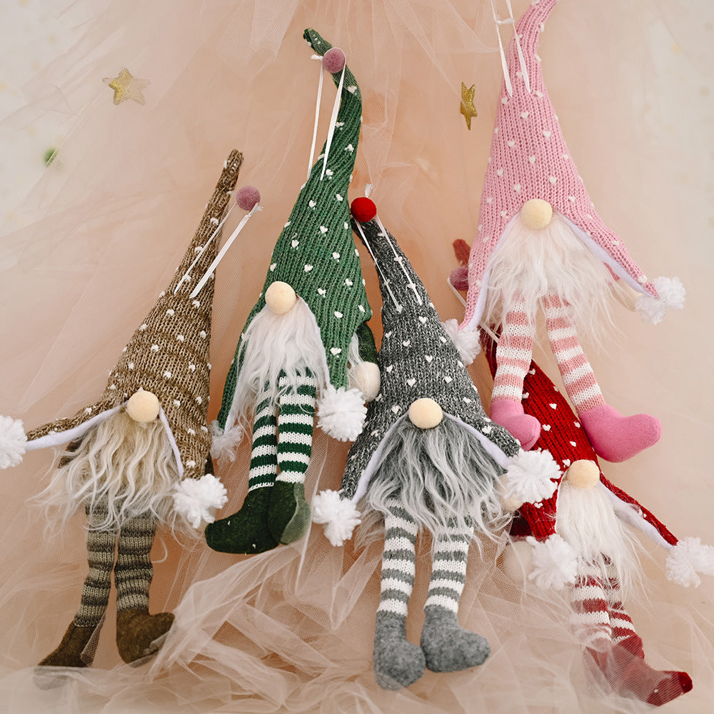 Knitted gnome ornaments in light gray, dark green, blush pink, and deep red with striped legs and fluffy beards.
