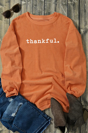 Orange corduroy oversized pullover sweatshirt with white thankful graphic and ribbed texture.