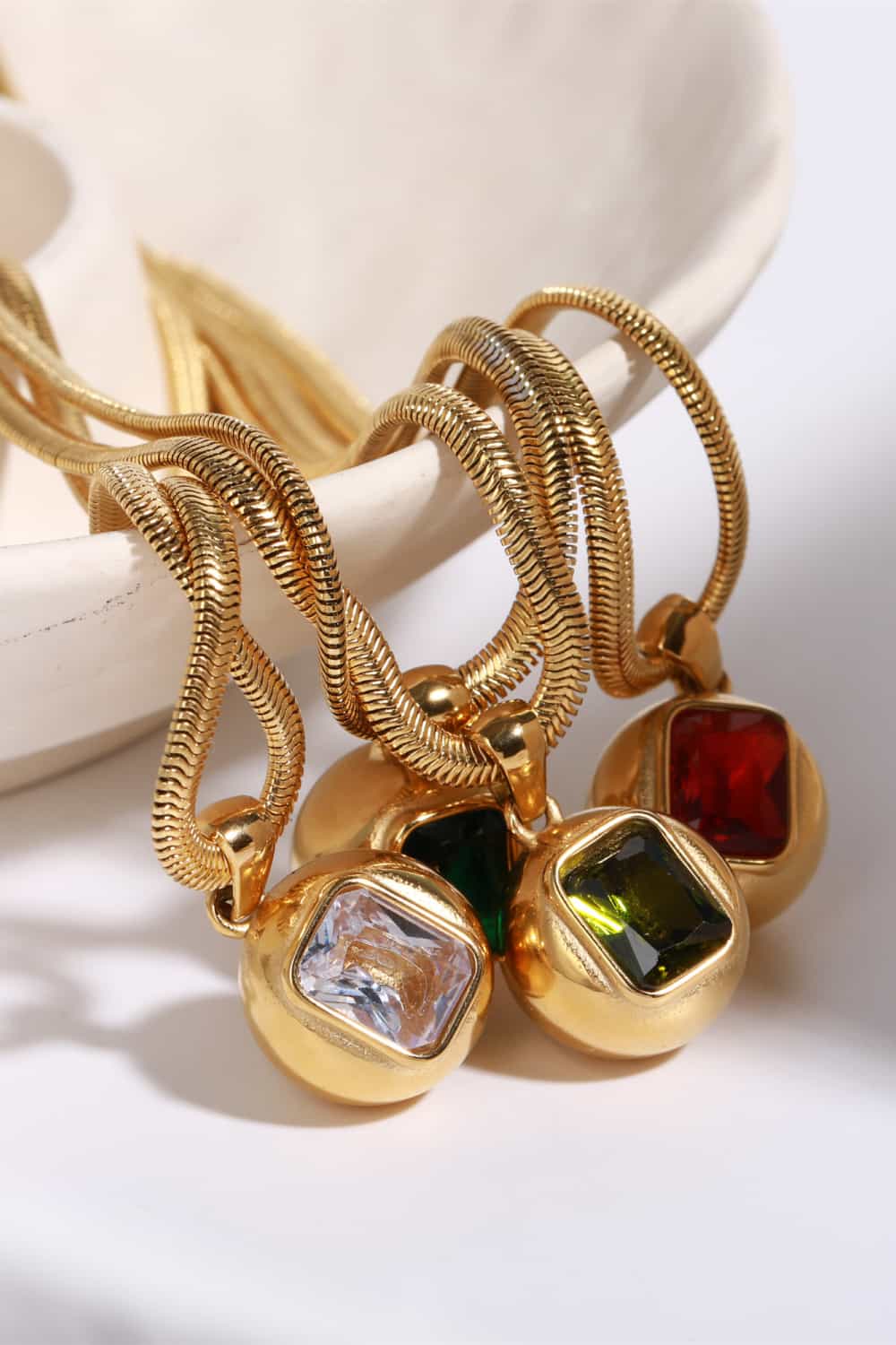 Sculpted Orb & Square Stone Necklace with gold chain and colorful gems in red, green, and clear.