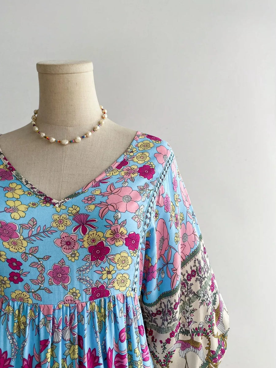 Light blue floral v-neck dress with bohemian print and peasant sleeves.
