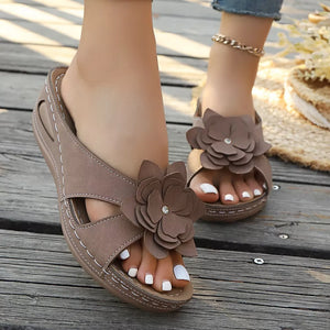 Brown floral embellished mid-wedge sandals with open toe and decorative flower detail.
