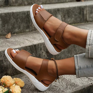 Brown adjustable open-toe platform sandals with chunky white soles.