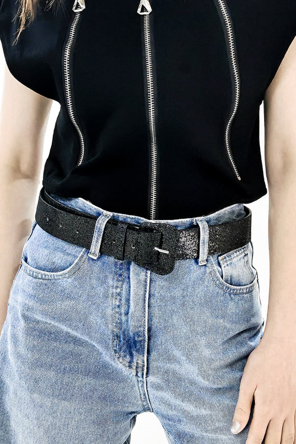 Black glitter belt with square buckle and multiple holes, worn with jeans.