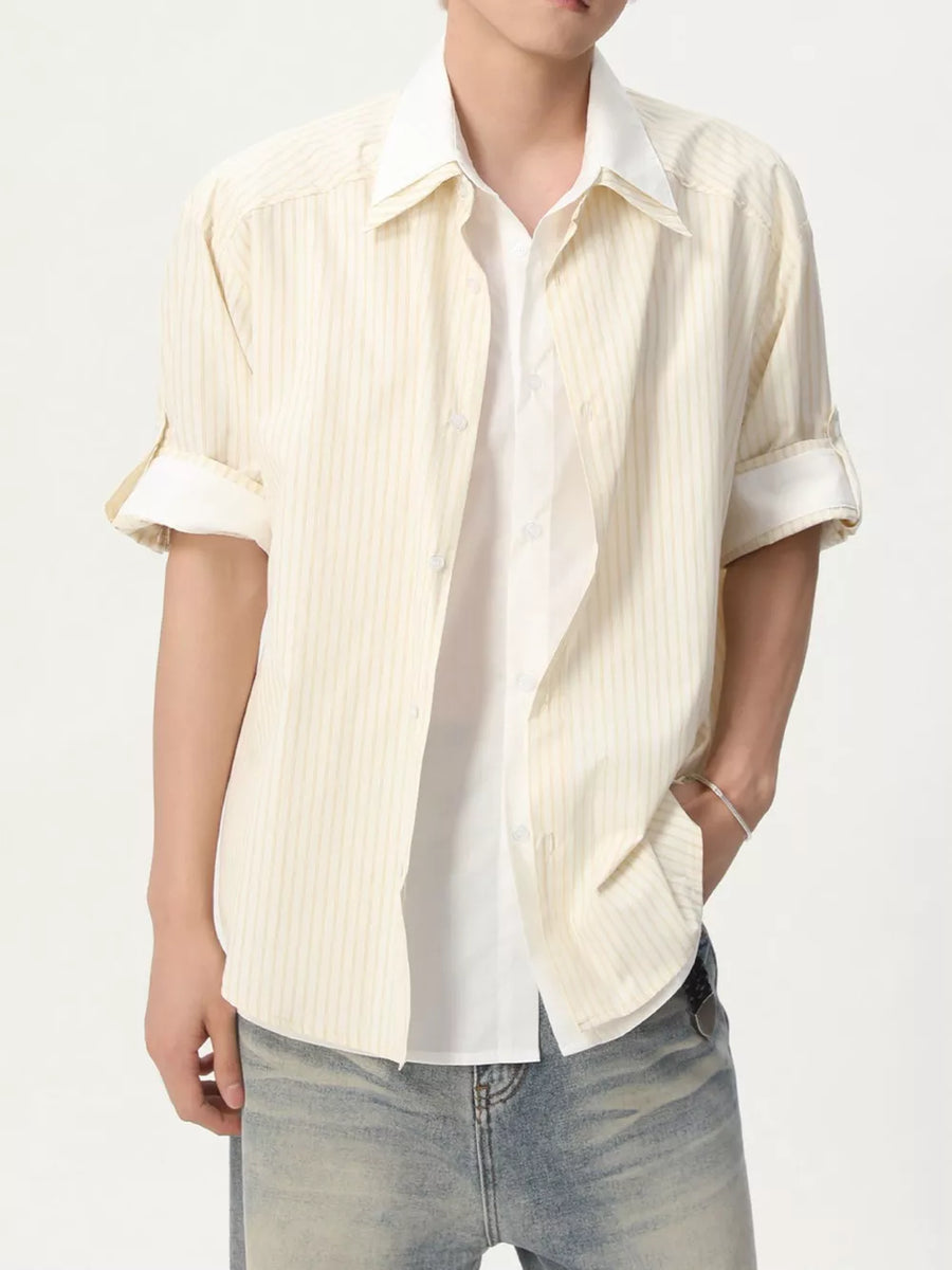 Men's yellow striped button-up shirt with rolled sleeves, layered over a white tee.
