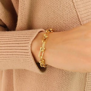 Gold sculptural link chain bracelet with small bead accents, 18k gold-plated.
