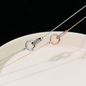Double circle pendant necklaces in silver and rose gold with crystal accents.