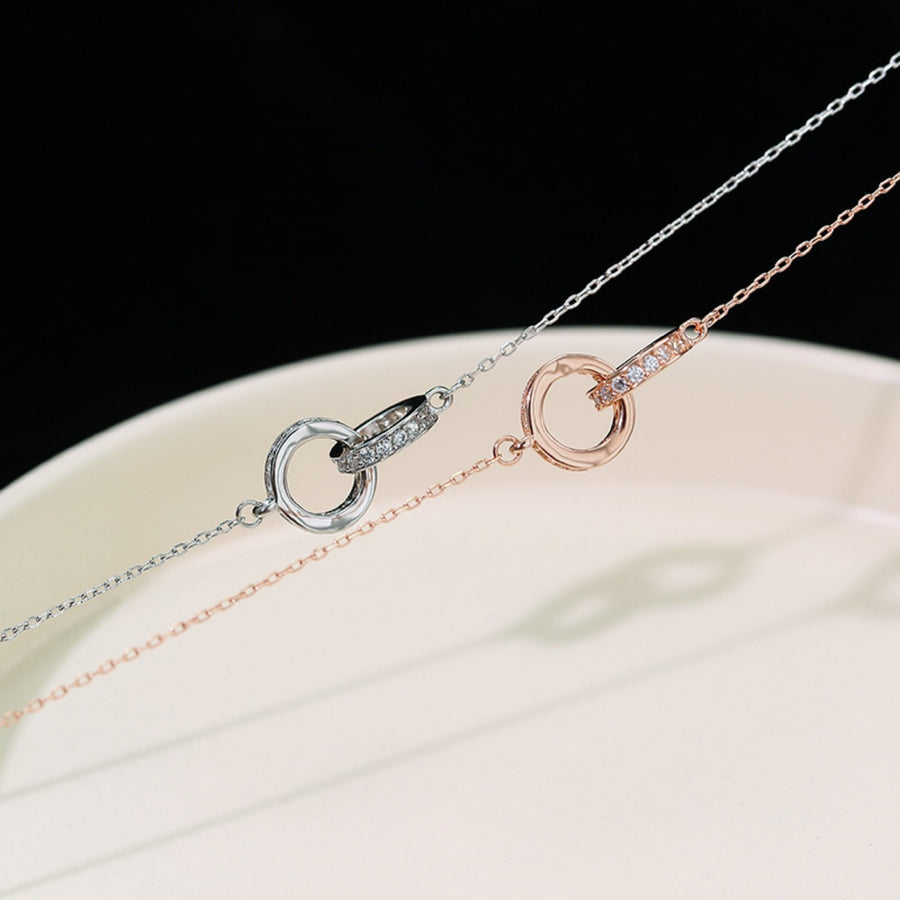 Double circle pendant necklaces in silver and rose gold with crystal accents.
