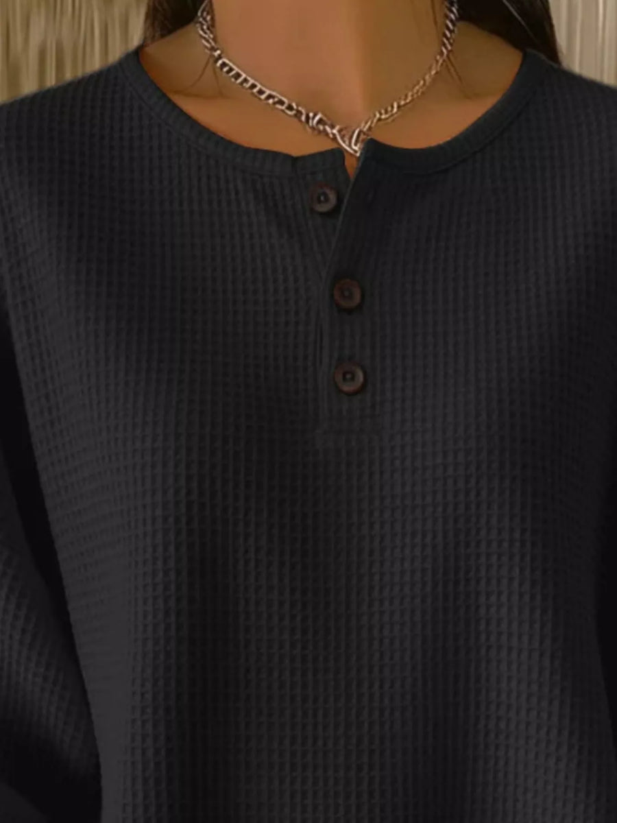 Black waffle knit henley top with button detail and crew neck.