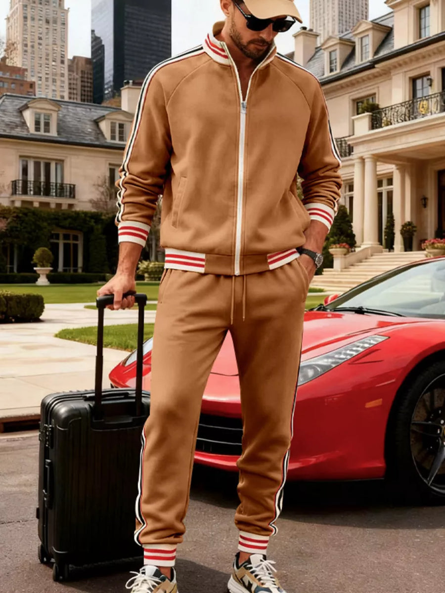Brown tracksuit with white and red striped cuffs and sleeves, zip-up jacket and jogger pants.