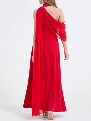 Red asymmetrical maxi dress with high slit and draped chiffon overlay.