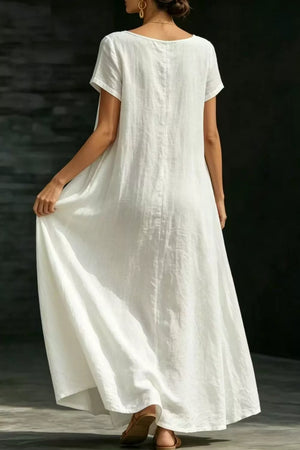 White polyester maxi dress with short sleeves and pockets, a-line cut.