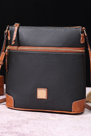 Black leather crossbody bag with brown trim and gold zipper.