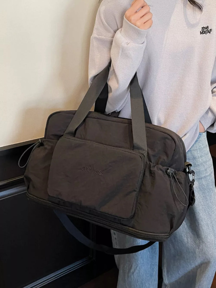 Black medium duffle bag with front pocket and side cinches