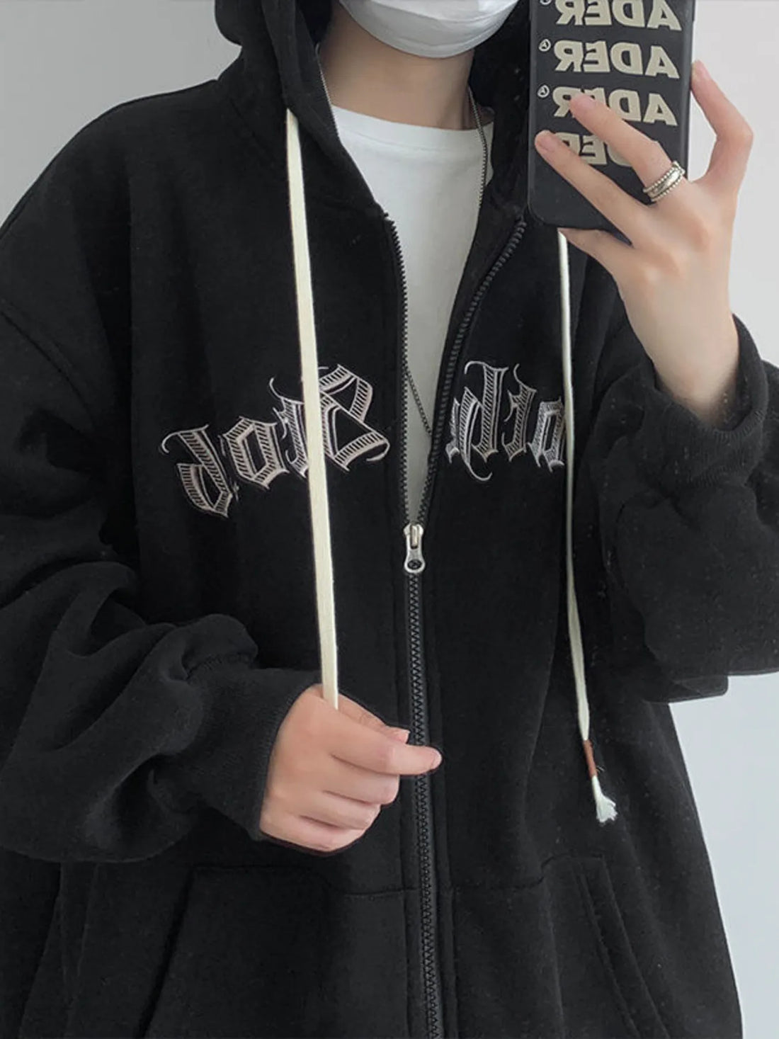 Black zip up hoodie with white drawstrings and gothic text graphic