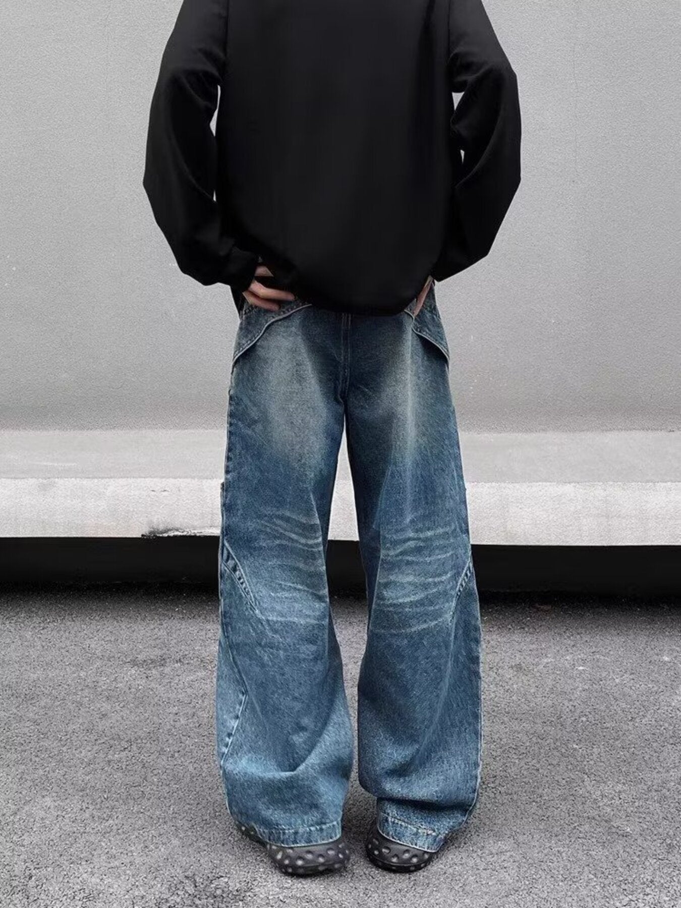 Men's washed blue wide-leg jeans in 100% cotton with distressed detailing and diagonal seams.