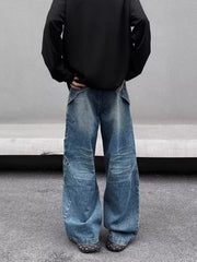Men's washed blue wide-leg jeans in 100% cotton with distressed detailing and diagonal seams.