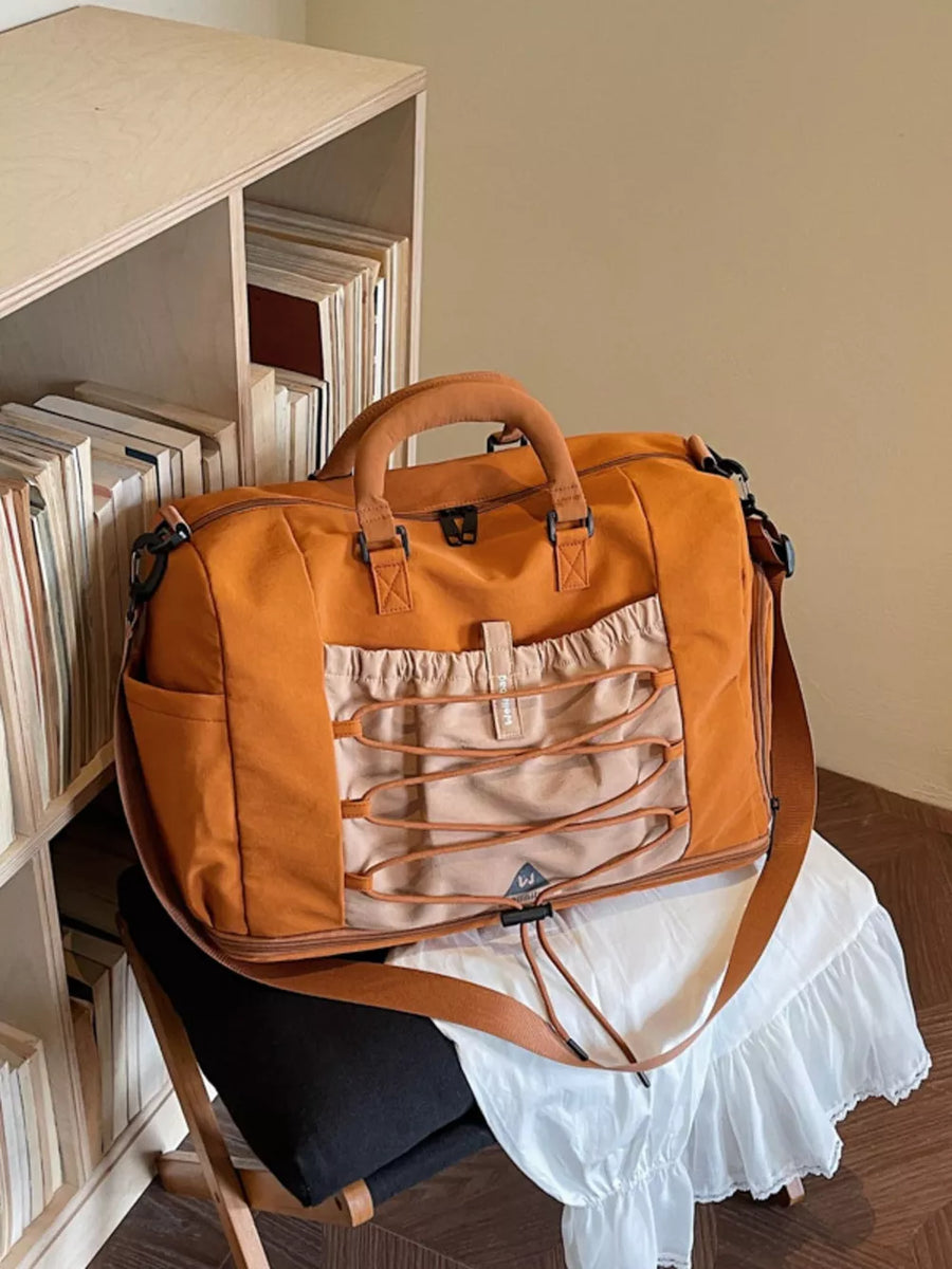 Orange nylon duffel bag with bungee cord detail and tan accents.