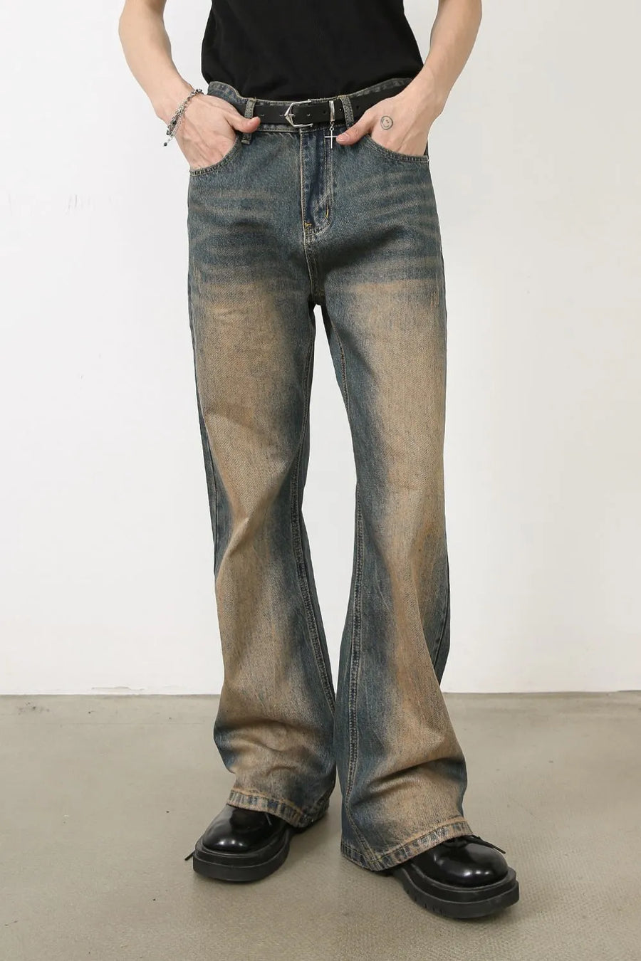 Faded wash bootcut denim jeans in medium color with distressed details.