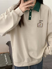 Textured waffle-knit polo sweatshirt in cream with green collar and button placket.
