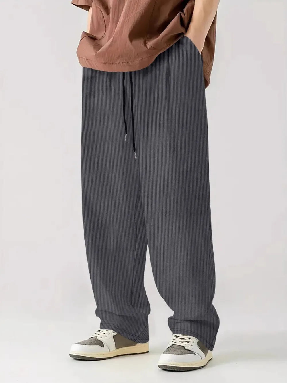 Textured corduroy relaxed fit trousers in dark gray with drawstring waist.