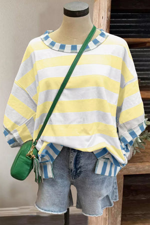 Striped crewneck sweatshirt with blue and white cuffs and neckline, paired with denim shorts.