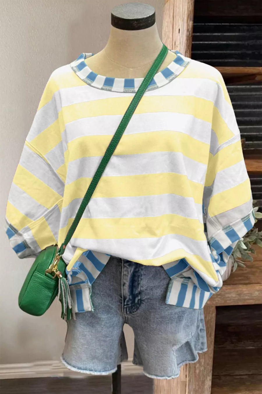 Striped crewneck sweatshirt with blue and white cuffs and neckline, paired with denim shorts.