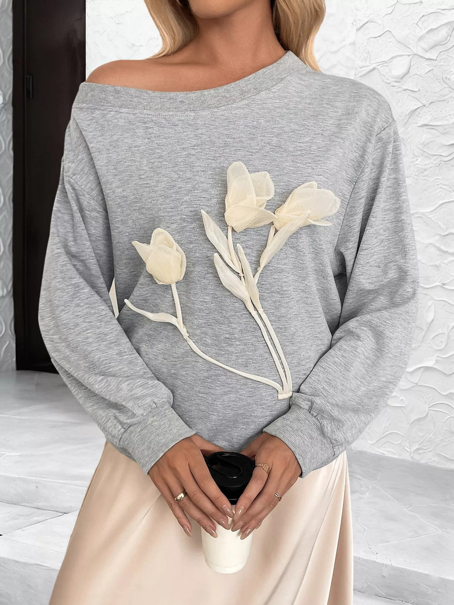 Gray boat neck sweater with delicate floral applique detail.