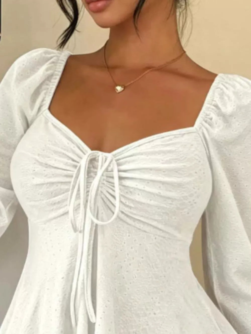 Black peplum top featuring tied and eyelet