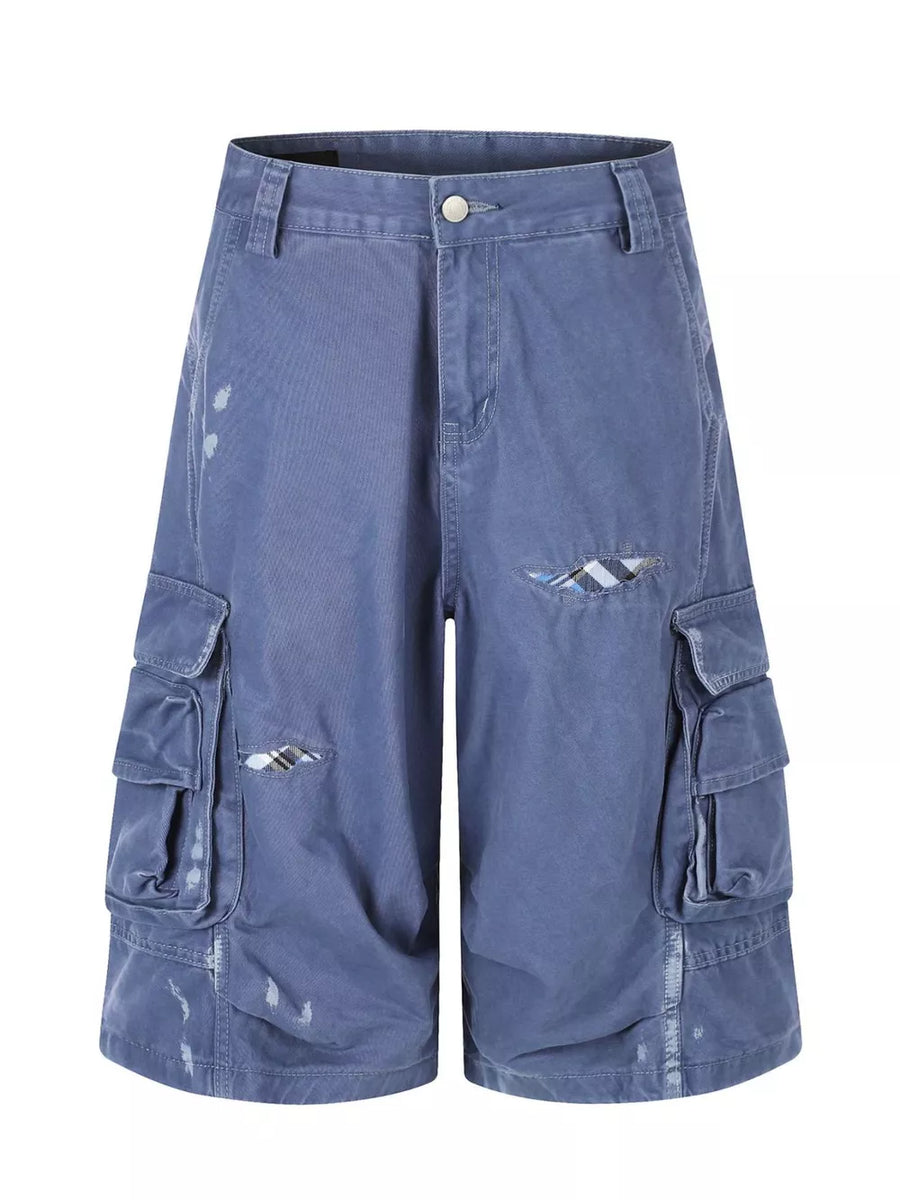 Blue faded cargo capris with distressed detailing and plaid accents.