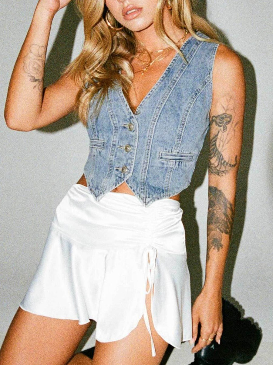 Chic V-neck button-up denim vest with cropped length and two chest pockets.