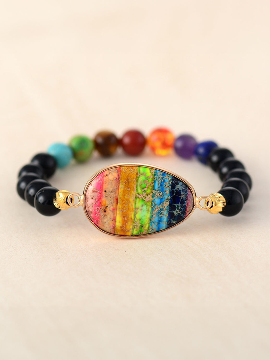 Prismatic bead and stone bracelet with multicolor agate center and black beads.