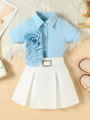 Blue floral appliqué shirt with white pleated skirt and decorative buckle