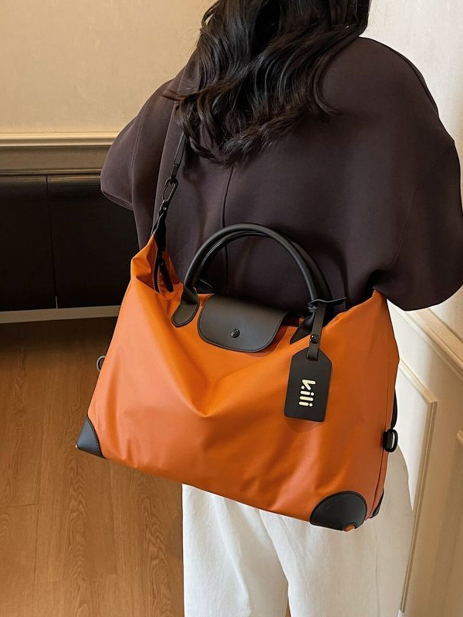 Orange travel duffel bag with black trim and a detachable luggage tag.