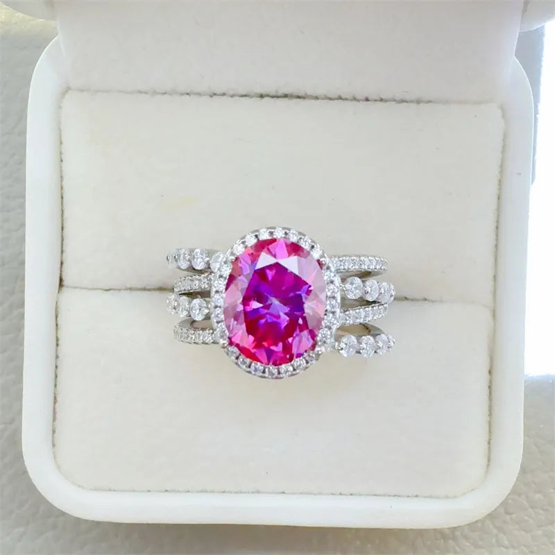 Silver ring with oval pink gem surrounded by small diamonds, stacked band design