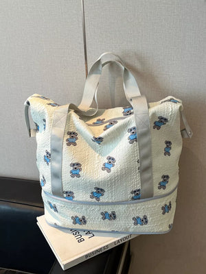 Tote bag with allover teddy bear print, textured fabric, and grey trim.
