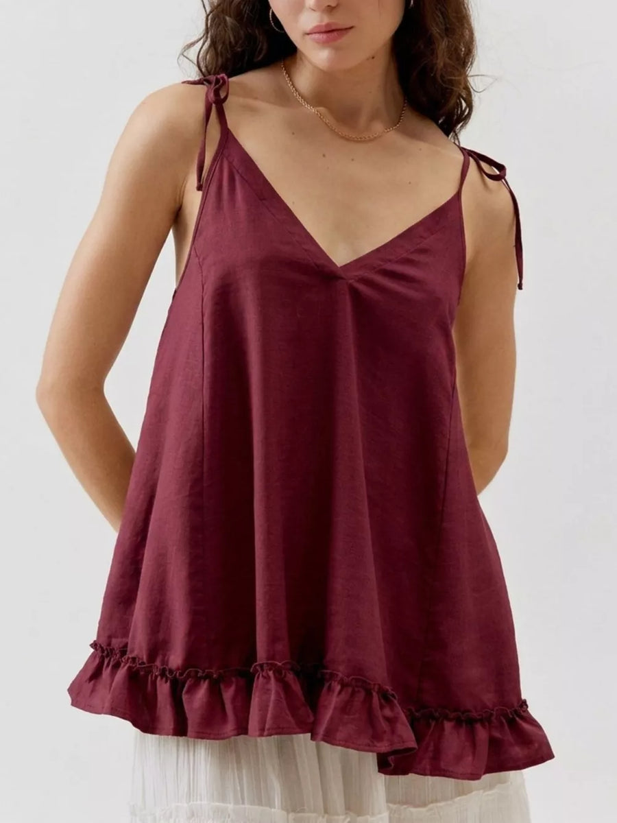 Burgundy camisole with tie straps and ruffled hem detail.