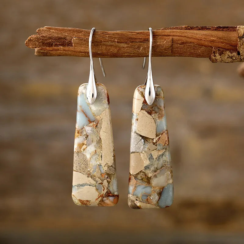 Textured stone drop earrings with silver hooks, featuring natural stone patterns in tan and blue.