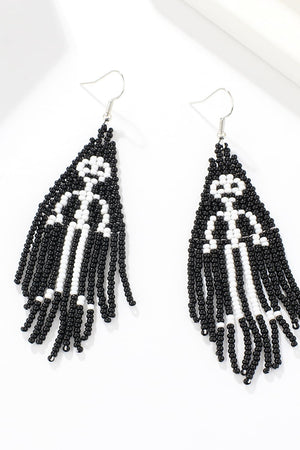 Beaded ghost fringe earrings in black and white with dangling strands.