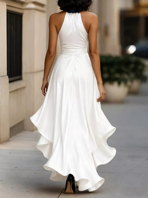 White halter maxi dress with ruffled asymmetrical hem and belted waist.