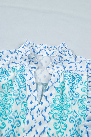 Patchwork mini dress with blue ikat and damask prints, V-neck, and ruffled collar.