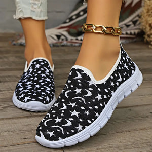 Black knit slip-on sneakers with white star and moon pattern.