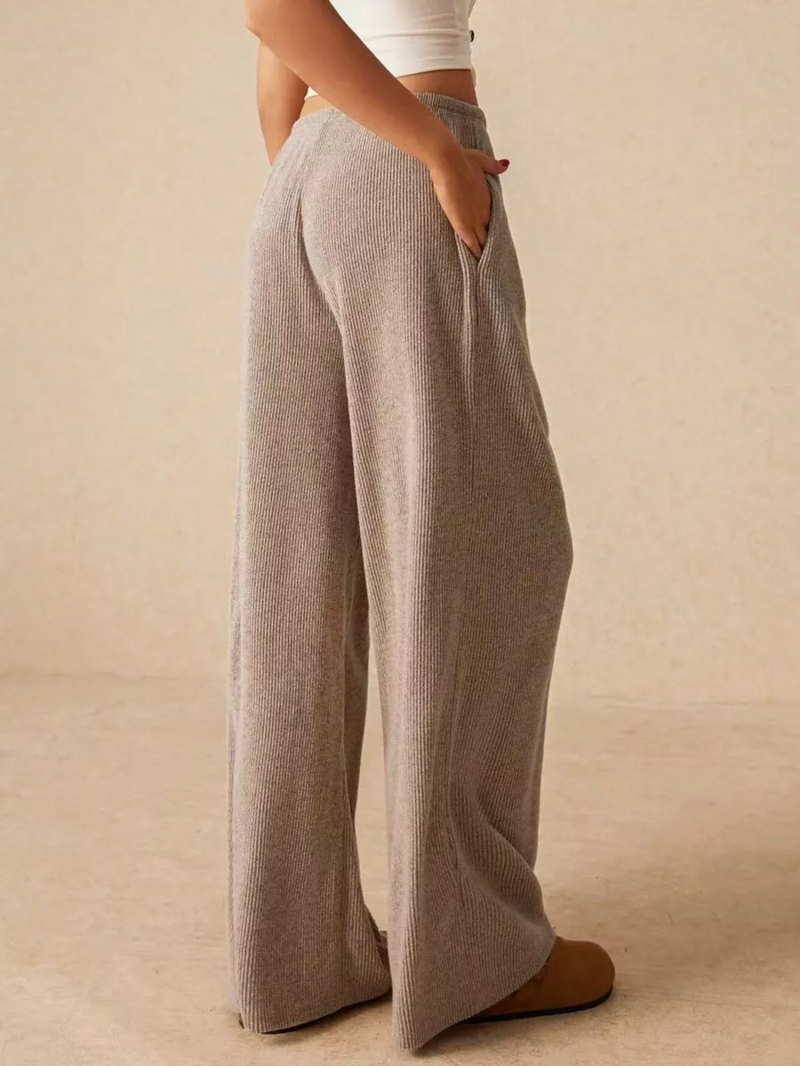 Gray ribbed wide-leg drawstring pants with pockets, styled casually.