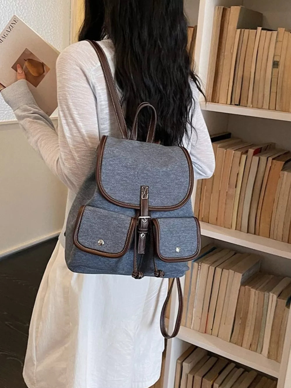 backpack in denim blue featuring flap pockets and boxy fit