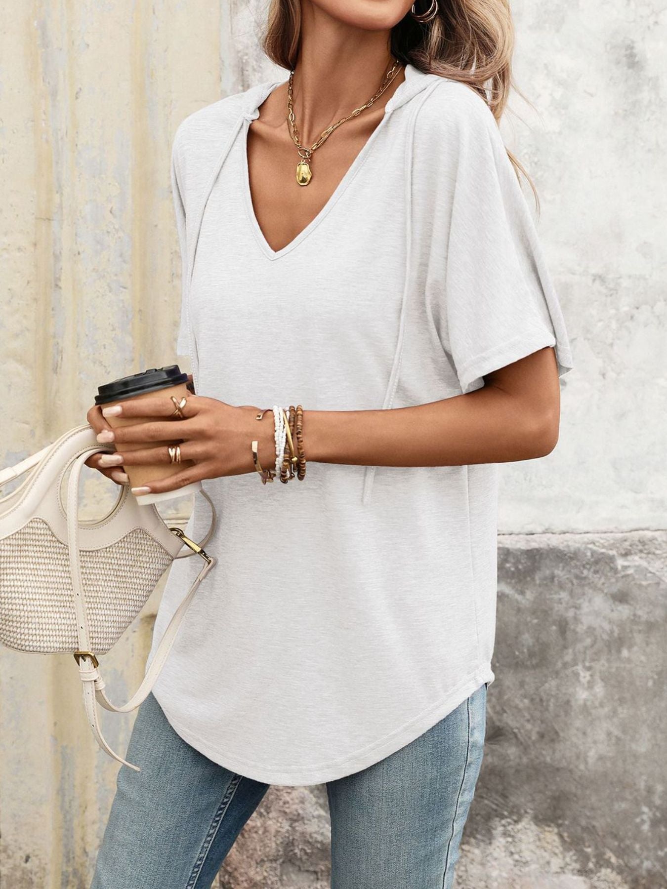 Relaxed short sleeve hooded t-shirt in gray/white with a v-neck and curved hem.