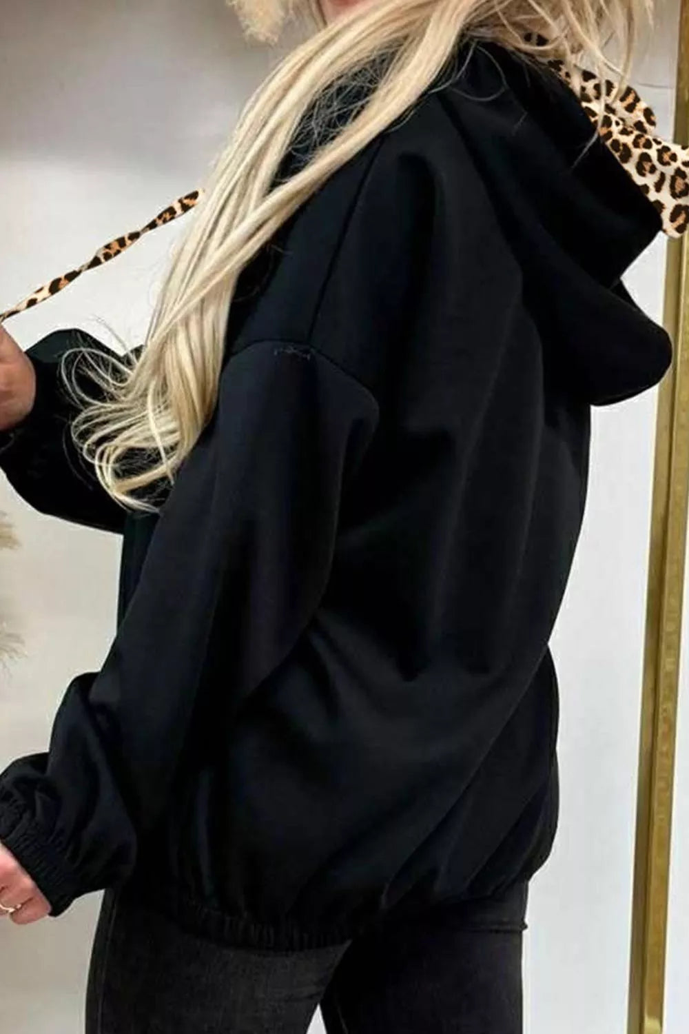 Black pullover hoodie featuring drawstring and leopard-print