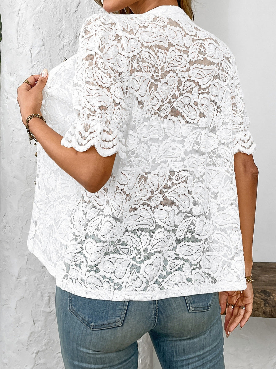 White floral lace blouse with mandarin collar and scalloped short sleeves.