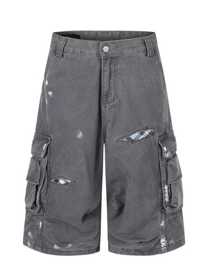 Gray cargo capris with distressed detailing and plaid patches.